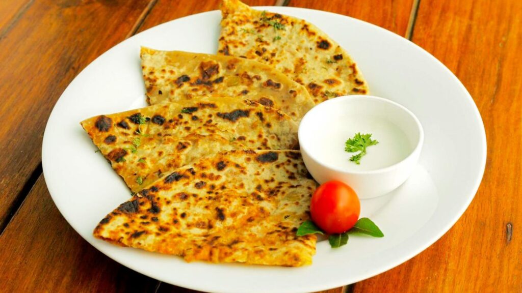 Healthy breakfast with aloo paratha served with fresh curd.
